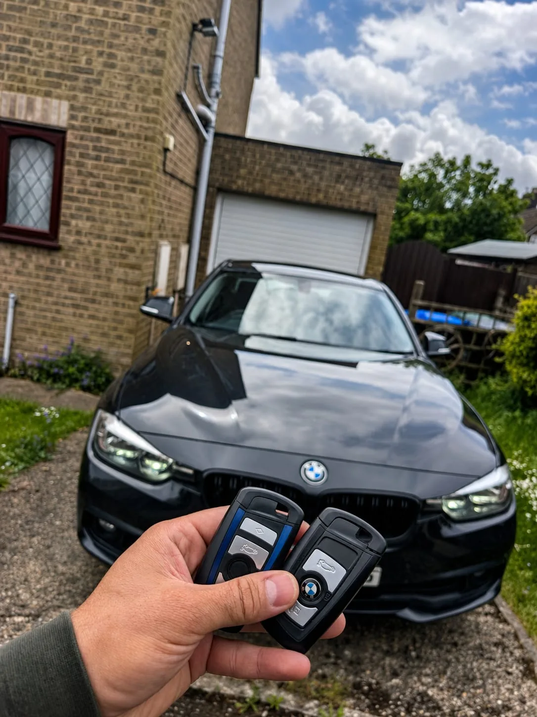 Two BMW 3 Series F30 keys held up in front of the car after programming — Long Buckby, Northamptonshire