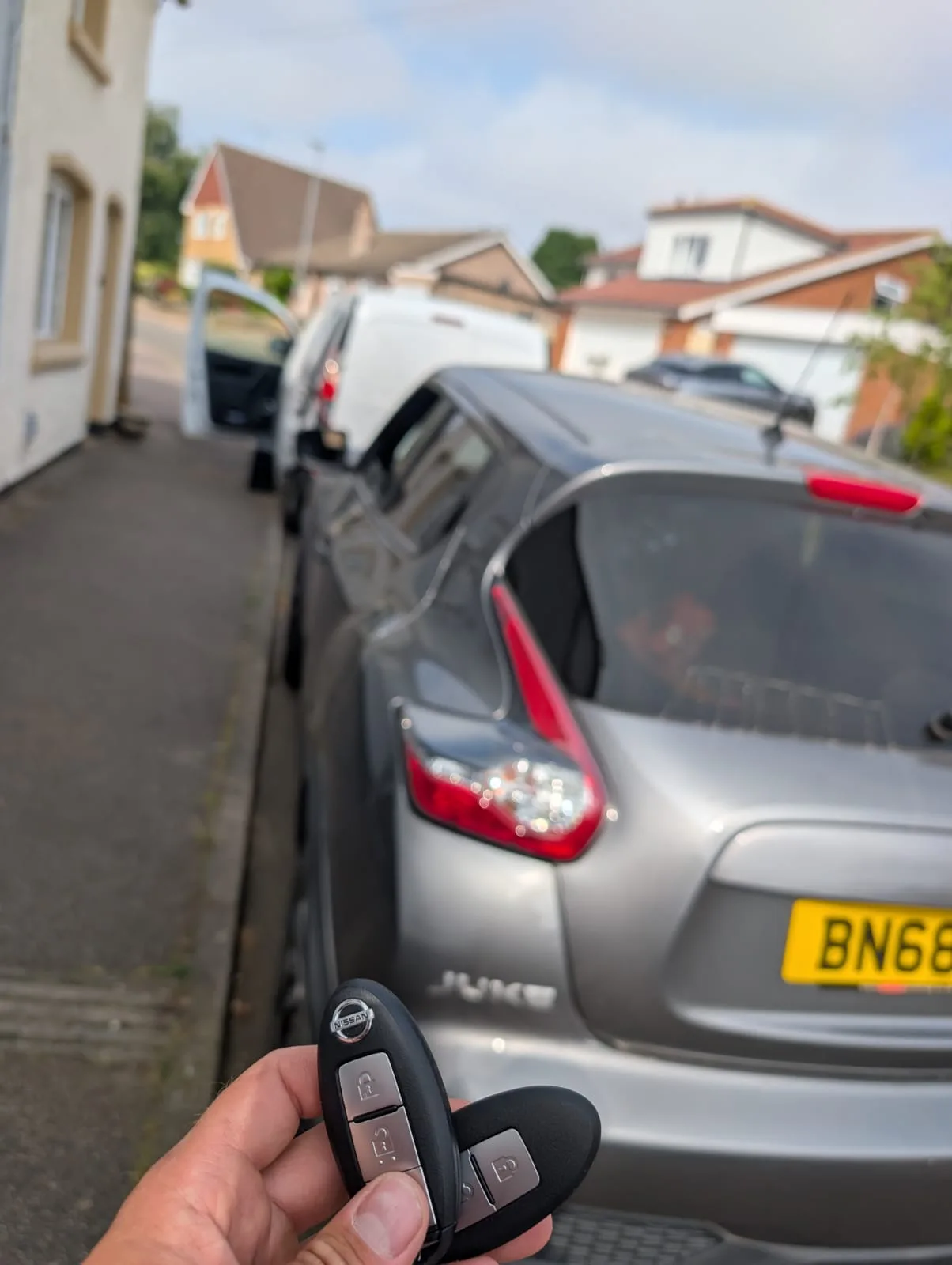 Nissan Juke 2018 in silver with a new smart key held up on a residential street in Daventry, Northamptonshire