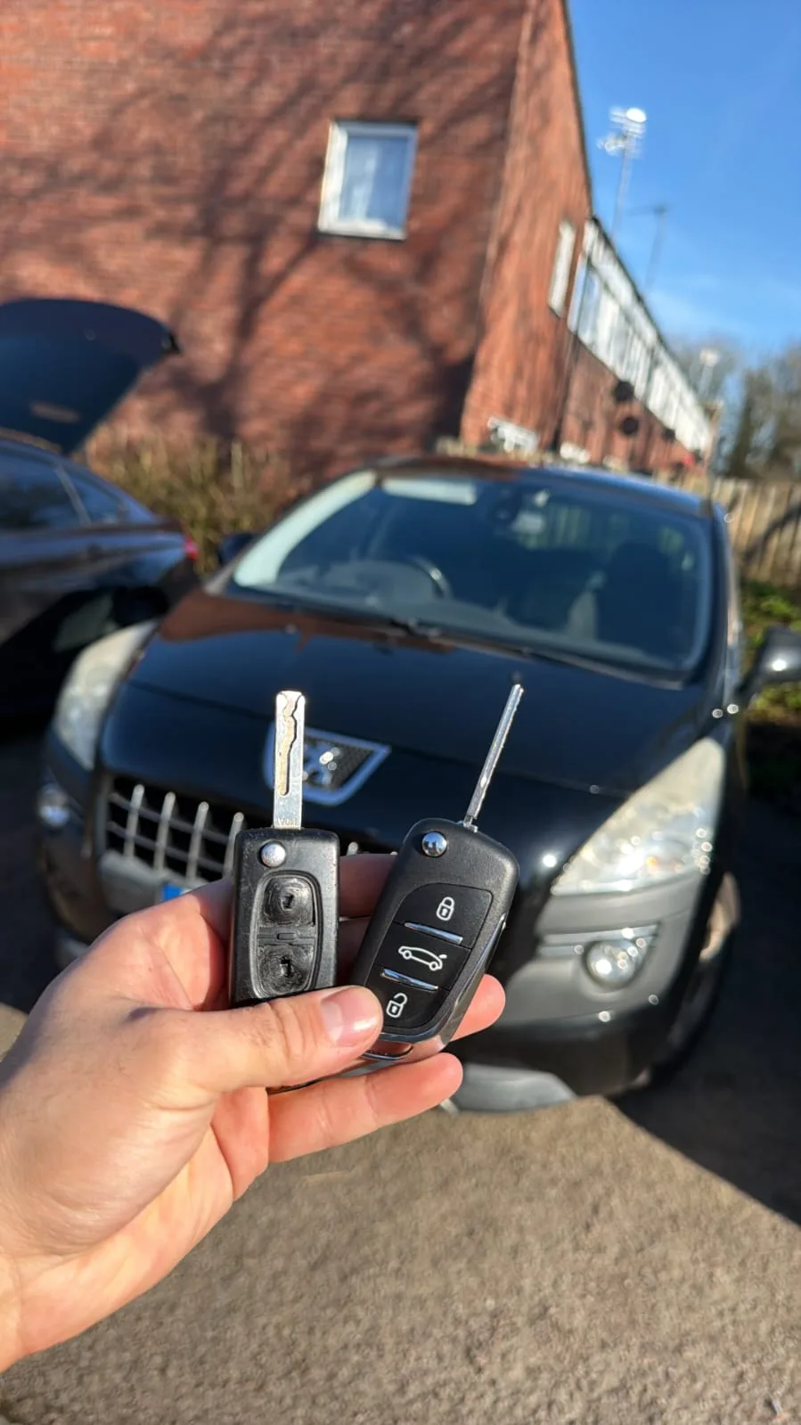 Peugeot 3008 2012 in black with old worn flip key and new replacement key programmed on-site in Milton Keynes