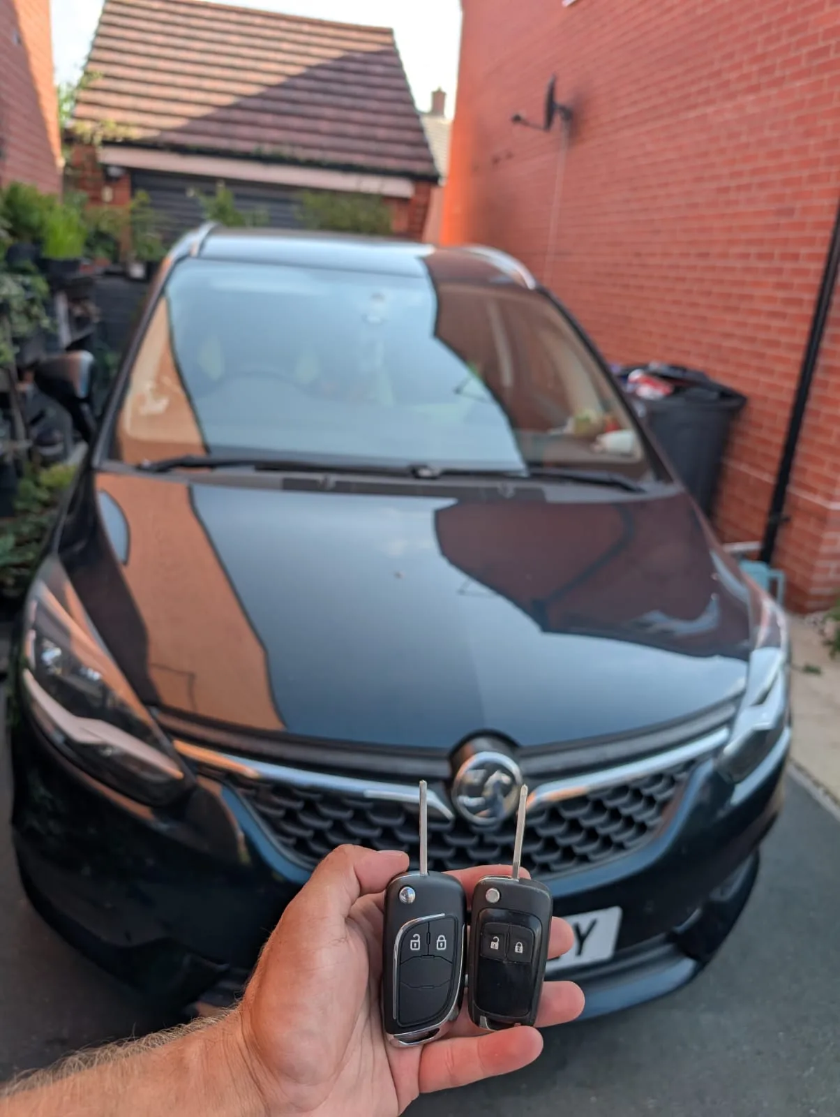 Vauxhall Zafira 2016 in black photographed from the front with two new flip keys held up in Southam, Warwickshire