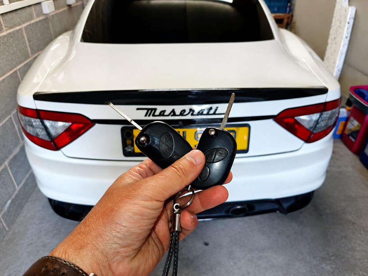 Auto locksmith with programming equipment at vehicle